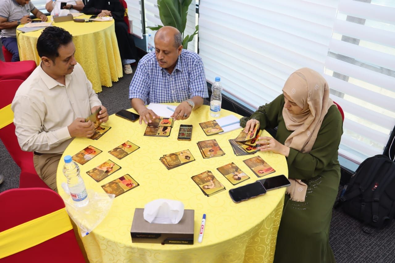 Participants reading customer character cards during a live simulation workshop