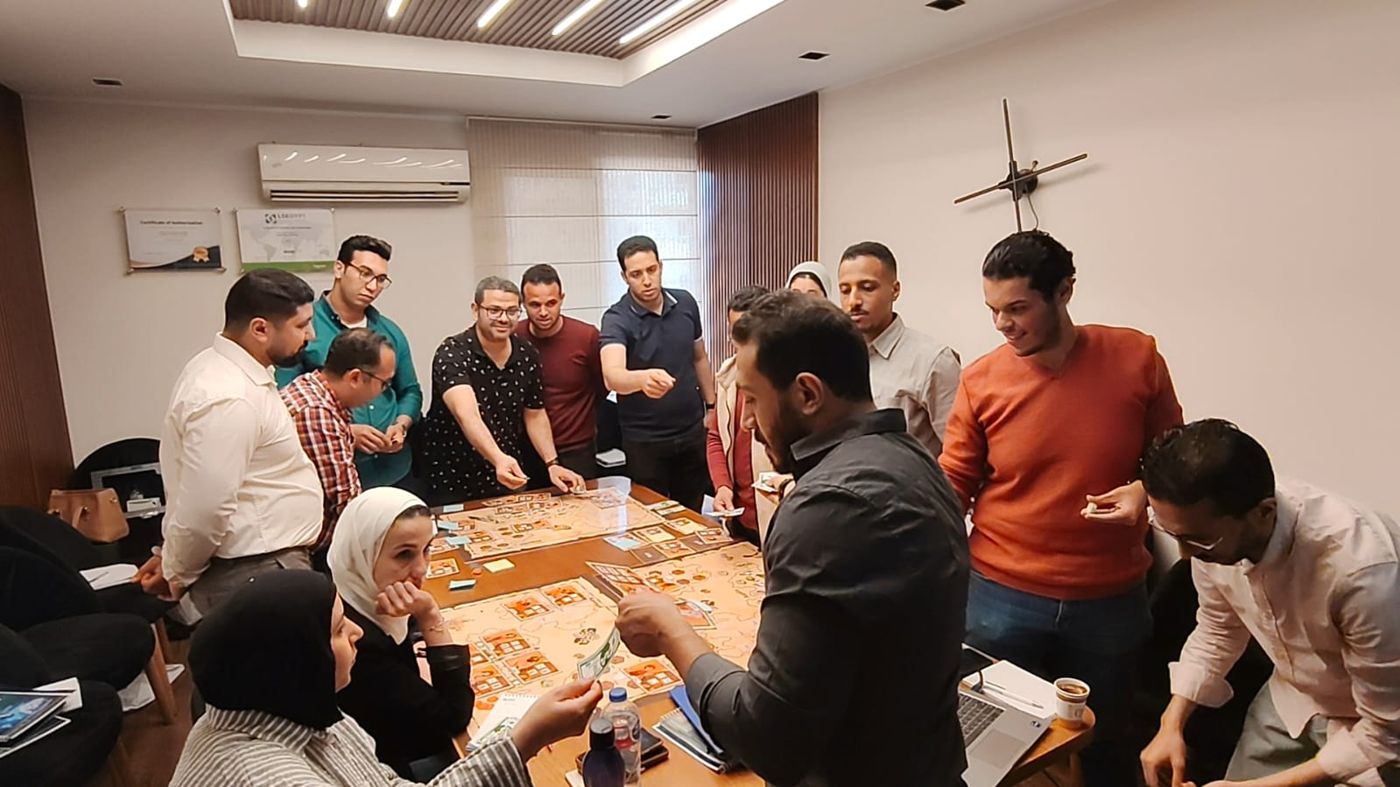 Participants exchanging game money over the simulation board